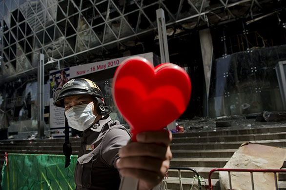 Thailand: A police officer with a heart shaped claper used by 'Red Shirt' protesters