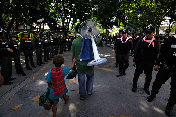 Thailand: An anti-government protester with his son leaves a temple