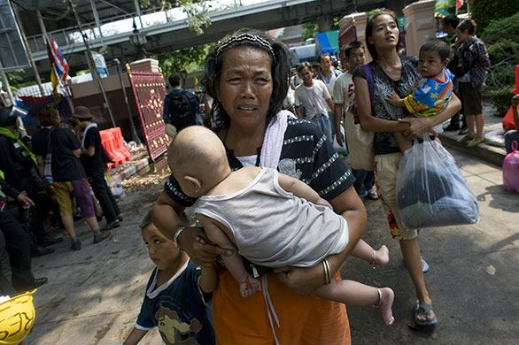 Thailand: A Red Shirt anti-government protester cries as she enters a police station