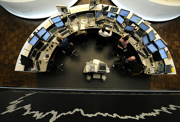 Week in business: Traders work in front of a board displaying German share index DAX