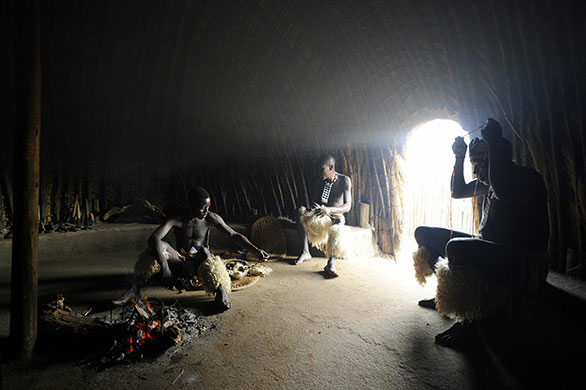 24 hours in pictures: Zulu dancers get ready in a hut to perform a traditional Zulu dance