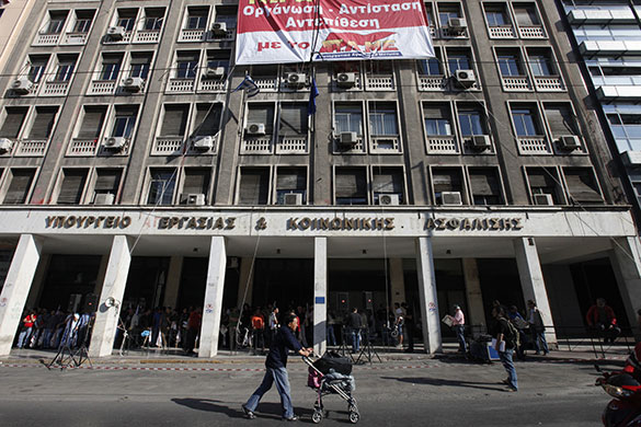 24 Hour Protest: A man walks past the Labor Ministry in 24 hour protest in Athens, Greece 