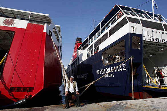 24 Hour Protest: A worker sits between docked ships during 24 hour protest in Athens, Greece