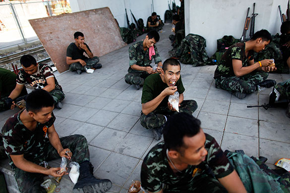 Thailand clean up: Thai soldiers eat their lunch after patrolling in central Bangkok