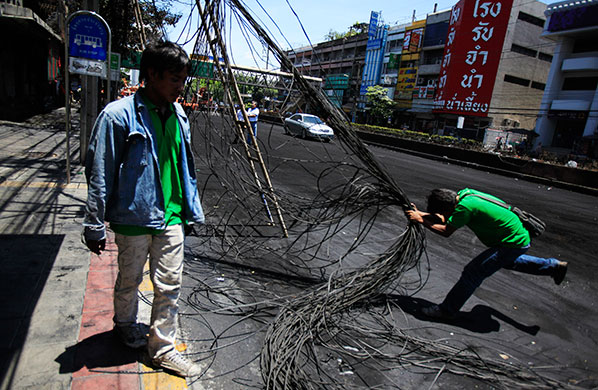 Thailand clean up: Workers untangle electrical wires destroyed by fire