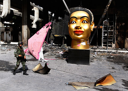 Thailand clean up: A Thai soldier patrols outside the destroyed shopping mall