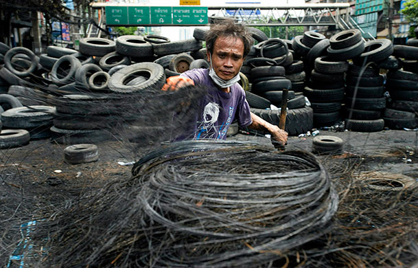 Thailand clean up: Steel belts from burned tires are gathered by collector along Rama IV Road