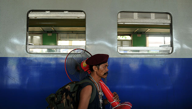 Thailand clean up: A Red Shirt protester arrives carrying his fan from Bangkok