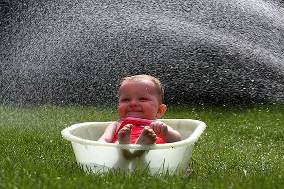 Seven-month-old Leila Gilmour enjoys a cool bath in Bannockburn, Scotland