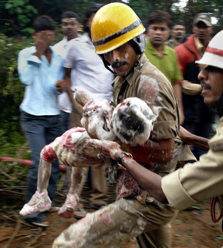 Indian firefighters carry a child from the wreckage of the Air India plane that crashed in Mangalore