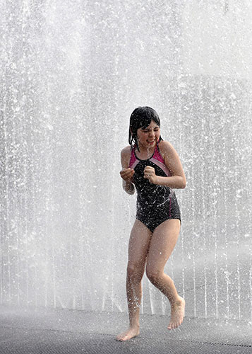 weather: A young girl cools down amongst the fountains of London's Southbank