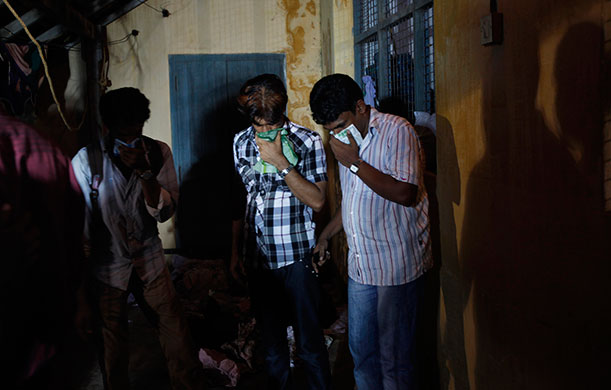 Air India plane crash: Relatives of victims cover their faces at a mortuary in Mangalore