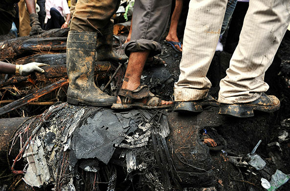 Air India plane crash: Rescue personnel and volunteers walk over wreckage at the crash site 