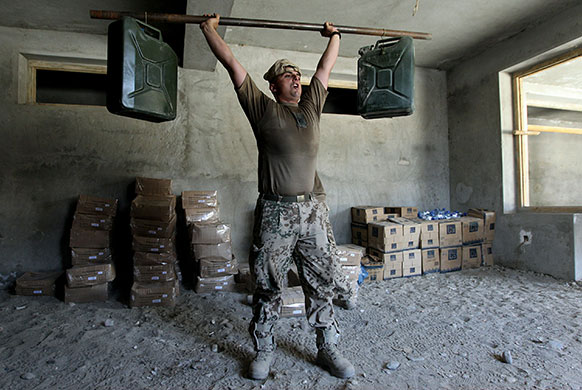 24hours: A soldier works out with selfmade barbells Chahar Darreh, Afghanistan