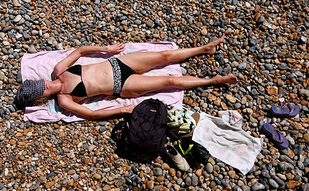 weather 2: A visitor to Brighton beach in East Sussex soaks up the sun