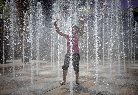 24 hours in pictures: Beijing, China: A girl has fun with a fountain outside a shopping mall