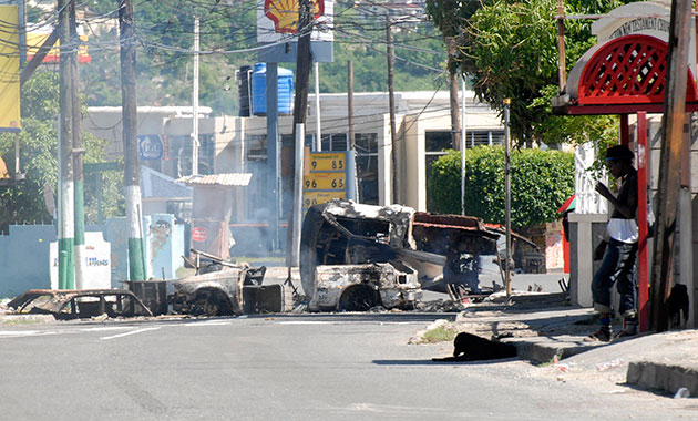 Jamaica: A resident stands by a road block in Kingston, Jamaica