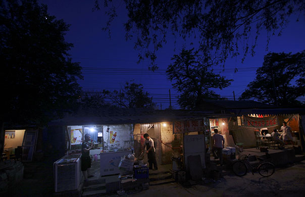 24 hours in pictures: Beijing, India: A man prepares food for a customer