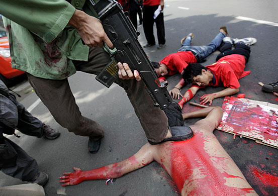 24 hours in pictures: Bangkok, Thailand: Protesters perform in an act depicting the crackdown