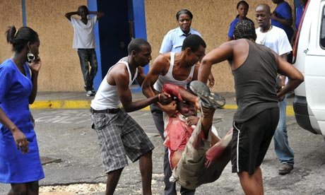 A wounded man is carried to hospital in Kingston during clashes with police and troops.