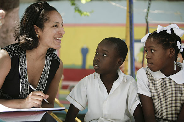 Haiti Schools Rebuild: A teacher smiles next to two young pupils