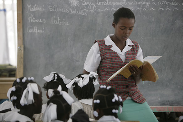 Haiti Schools Rebuild: A teacher reads to immaculately dressed pupils