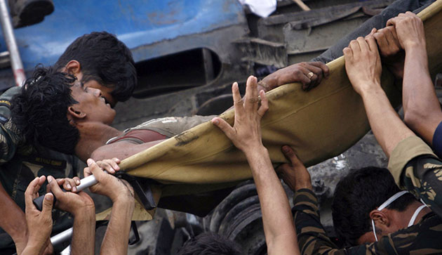 India train crash: Soldiers and rescue workers move an injured passenger from a carriage