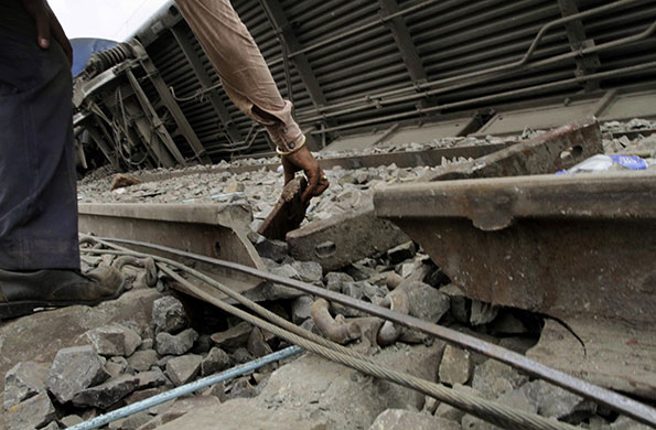 India train crash: A railway employee looks at the broken rail track