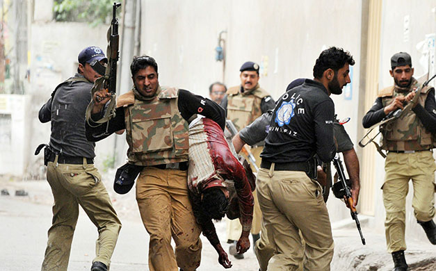 Lahore attack: Pakistani commandos make way for a colleague carrying an injured worshipper