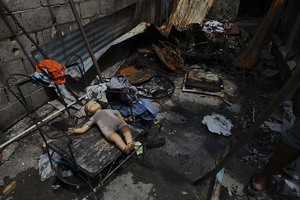 24 hours in pictures: Kingston, Jamaica: A doll on the floor of a house that was burnt