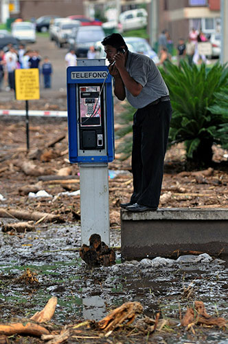 24 hours: Palin, Guatemala: A man talks on the phone after the first tropical storm