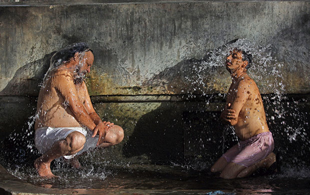 24 hours: Amritsar, India: Indian men cool off as they shower at a bathing place 