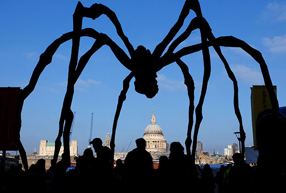 People walk beneath Maman outside the Tate Modern