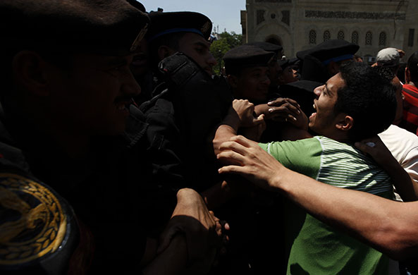 24 hours in pictures: Cairo, Egyp: An opposition activist scuffles with riot police