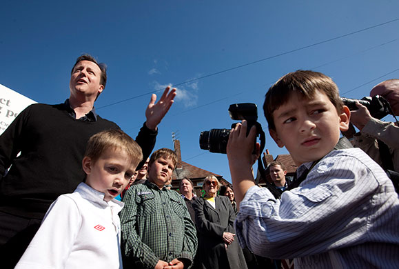 Cameron campaign trail: David Cameron is photographed by a young boy at an event in Blackpool