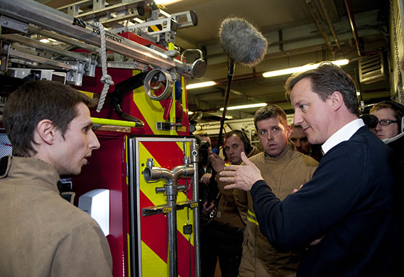 Cameron's 24 hours: David Cameron, right, listens to firemen at Carlisle fire station 