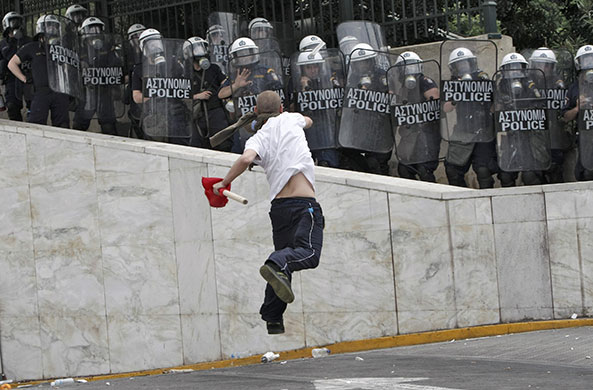 Strike in Greece: A demonstrator hurls projectiles at riot police