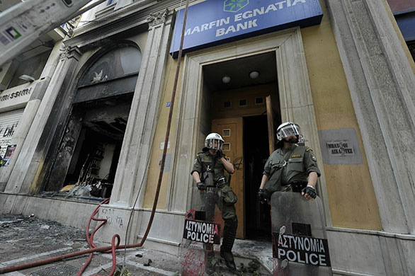 Strike in Greece: Riot police stand in front on burnt out Marfin Egnatia bank