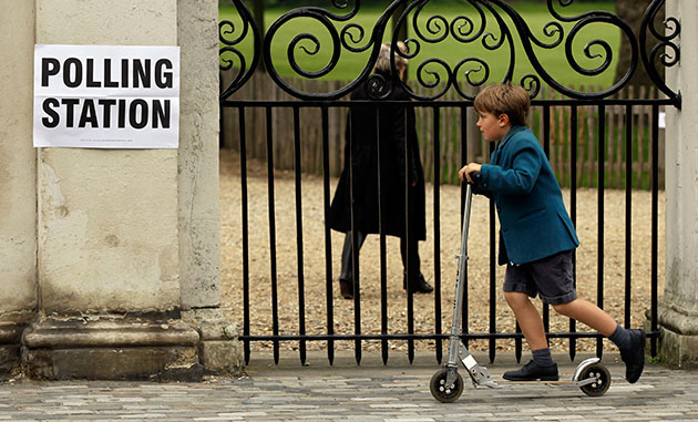 Voting Gallery: A school-boy passes a sign outside a polling station in London