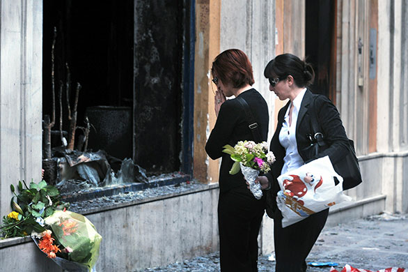 Greece Riots: Women put flowers in front the bank 