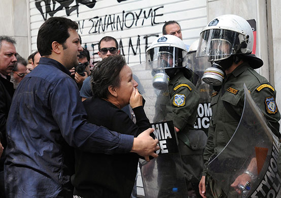 Greece Riots: A relative of a bank employee outside the torched bank