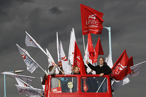 Week in business: Strikers wave flags from a double decker bus near Heathrow airport