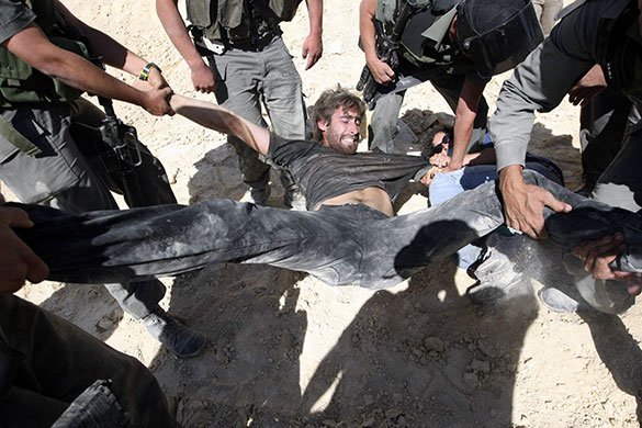24 hours in pictures: al Wallaje, West Bank: A foreign activist is carried away by border police