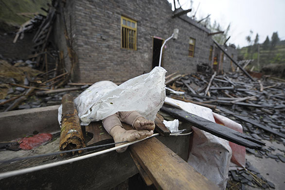 24 hours in pictures: Dianjiang, China: The body of a girl who was killed during a tornado