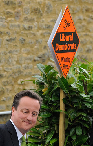 MPs voting: David Cameron passes a Liberal Democrat sign after voting