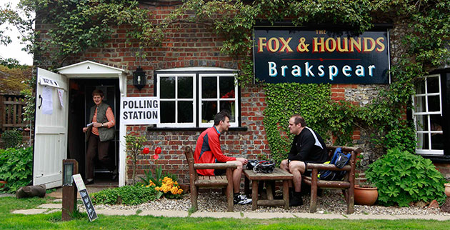 Voting updated: Men sit outside The Fox and Hounds pub polling station in Christmas Common