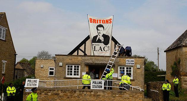 Voting updated: Police erect a ladder to remove protestors on the roof of a polling station