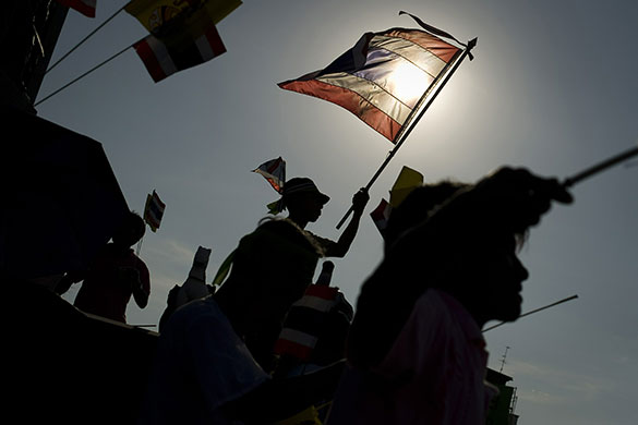 24 Hours in Pics: Thai pro-government demonstrators hold national flags during a small rally