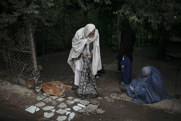 24 Hours in Pics: An elderly Afghan man stands near a burqa-clad woman in Kabul