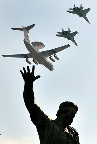 Victory parade: A Russian A-50 plane and Su-27 fighter jets fly over a statue 